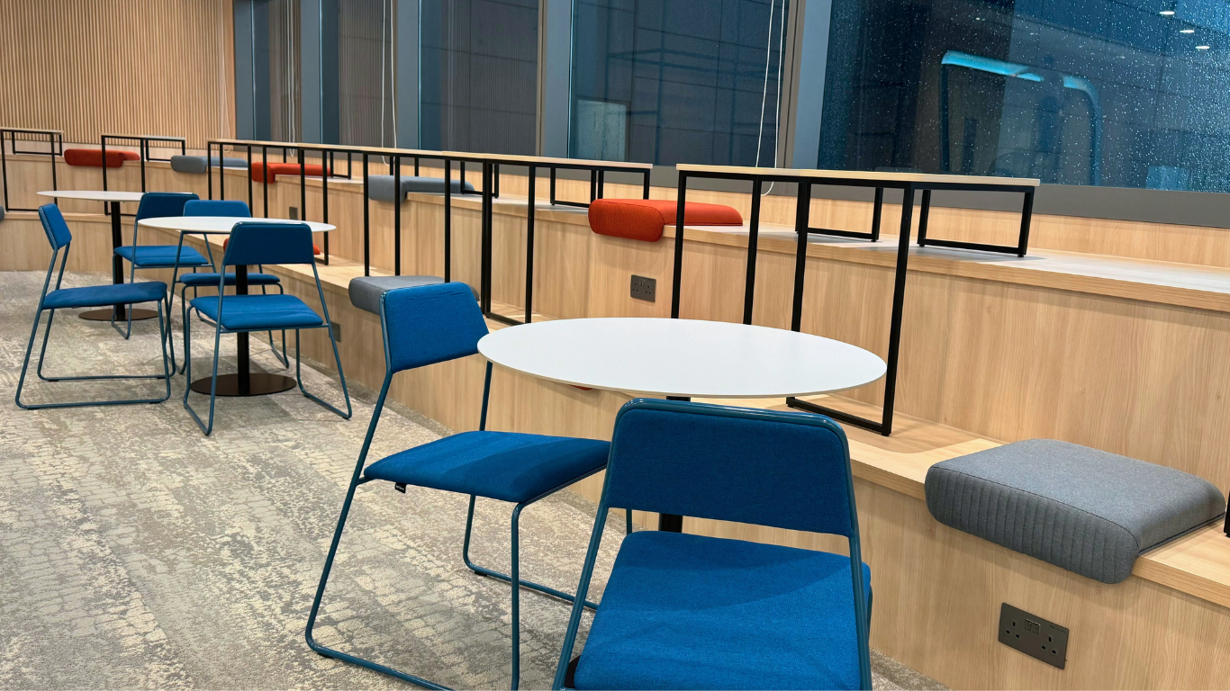  Overview of the dining area with Swan Dining Chairs, sintered stone round dining tables, and the stepped seating area with Tail Seat Cushions.